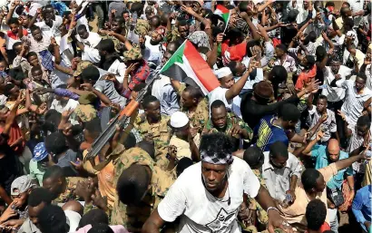  ?? Reuters ?? Sudanese military members control demonstrat­ors as they protest near the Defence ministry in Khartoum on friday. —