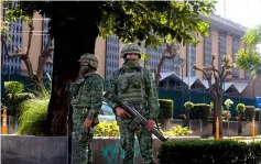  ??  ?? Members of the Mexican Army stand guard outside the US Consulate in Guadalajar­a, after an attack with an explosive device left a wall damaged but nobody injured. — AFP photo