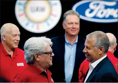  ?? AP/CARLOS OSORIO ?? United Auto Workers Local 600 President Bernie Ricke (left) talks with Ford Motor Co. automotive division President Joseph Hinrichs in July after opening contract talks in Dearborn, Mich. The UAW said late Wednesday that it has reached a tentative contract agreement with Ford.