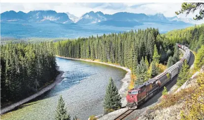  ?? ?? „The Canadian“fährt am Bow River vorbei, der durch endlose Wälder mäandert, dahinter sind die Rocky Mountains