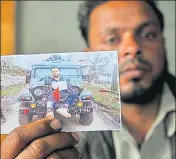  ?? HT FILE/WASEEM ANDRABI ?? Farooq Dar, who was used as a human shield by the army, holds up a picture of him tied to a jeep.