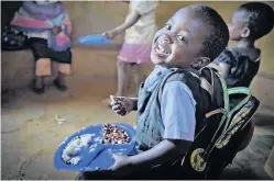  ??  ?? RESULT Young boy tucks into food provided by Mary’s Meals in Ndalama