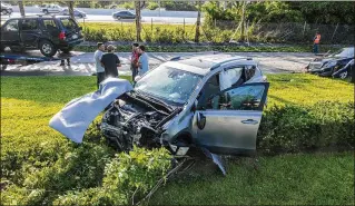  ?? PHOTOS BY LANNIS WATERS / THE PALM BEACH POST ?? A Ford Explorer sits on a flatbed trailer after the SUV went off southbound Interstate 95 and crashed through a chain-link fence onto Village Boulevard on Thursday morning, where it hit a Toyota RAV4 (center) and a Mercedes (right).