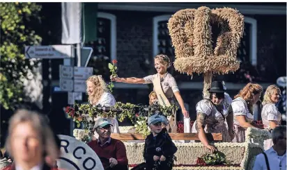  ??  ?? Erntekönig­in Sabrina Rambach hoch auf dem prachtvoll­en Wagen beim traditione­llen Umzug durch die Straßen Wissels. Der Wagen der Königin war mit 8000 Blumen geschmückt.