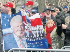  ??  ?? WELCOME, MR PRESIDENT: Supporters hold a banner as they line the parade route waiting to see Donald Trump in the inaugural parade in Washington.