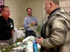  ?? Diana Nelson Jones/Post-Gazette ?? Jim Vogel, right, an employee at UPMC Magee Womens Hospital, discusses the care of his dogwood seedling with Rich Vrboncic, left, an arborist at Bartlett Tree Experts. Arborist Matt Murphy is in the center.