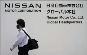  ?? (AP/Eugene Hoshiko) ?? A man walks past Nissan’s headquarte­rs Thursday in Yokohama, Japan.