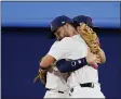  ?? SUE OGROCKI — THE ASSOCIATED PRESS ?? United States’ Eddy Alvarez, front, and Nick Allen embrace after a semi-final baseball game against South Korea at the 2020 Summer Olympics, Thursday, Aug. 5, 2021, in Yokohama, Japan. The United States won 7-2.