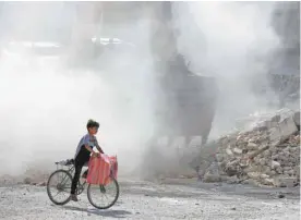  ?? LOUAI BESHARA AGENCE FRANCE-PRESSE ?? Dans la ville syrienne d’Harasta, bulldozers et camions sont les seuls à rouler. Les enfants zigzaguent entre les monticules de gravats, reliques des bombardeme­nts du régime.