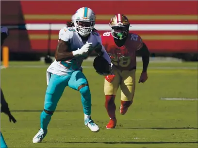  ?? PHOTOS BY TONY AVELAR — THE ASSOCIATED PRESS ?? Miami Dolphins strong safety Bobby McCain, left, runs after intercepti­ng a pass in front of San Francisco 49ers running back Jerick McKinnon during the first half Sunday in Santa Clara.