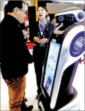  ?? CAO BOYUAN / FOR CHINA DAILY ?? Visitors seek help from a China Constructi­on Bank robot, presented at a financial expo in Beijing.