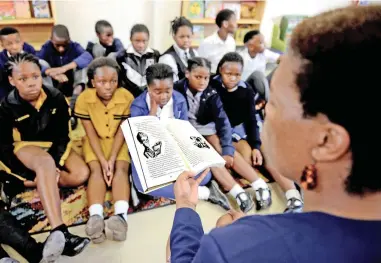  ?? PICTURE AYANDA NDAMANE/ AFRICAN NEWS AGENCY/ANA ?? NEW CHAPTER: Xolisa Guzula reads from ‘George’s Secret Key to the Universe’ by Lucy and Stephen Hawking to children at the Molo Mhlaba primary school.