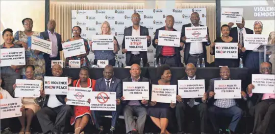  ??  ?? Above: Delegates make a stand against violence and intimidati­on against councillor­s and municipal managers. 0 - Right: A member of the audience examines a poster launched on Violence in Democracy. Below: Sakina Kamwendo moderator of panel debate on...