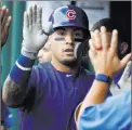  ?? Jacquelyn Martin ?? The Associated Press Javier Baez is greeted in the Cubs’ dugout Thursday after hitting a home run in the sixth inning of Chicago’s 4-3, 10-inning win at Nationals Park.