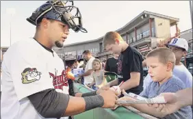  ?? John Carl D'annibale / Times Union ?? Ex-catcher Alfredo Gonzalez signs autographs for fans in Troy, where the Valleycats have spent the past 18 seasons as a Houston Astros affiliate.