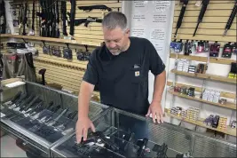  ?? HAVEN DALEY — THE ASSOCIATED PRESS FILE ?? John Parkin, co-owner of Coyote Point Armory. displays a handgun at his store in Burlingame.