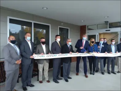  ?? MELISSA SCHUMAN — MEDIANEWS GROUP ?? With the help of town and state elected officials, Dr. George Silver gets ready to cut the ribbon for OrthoNY’s new Clifton Park location.