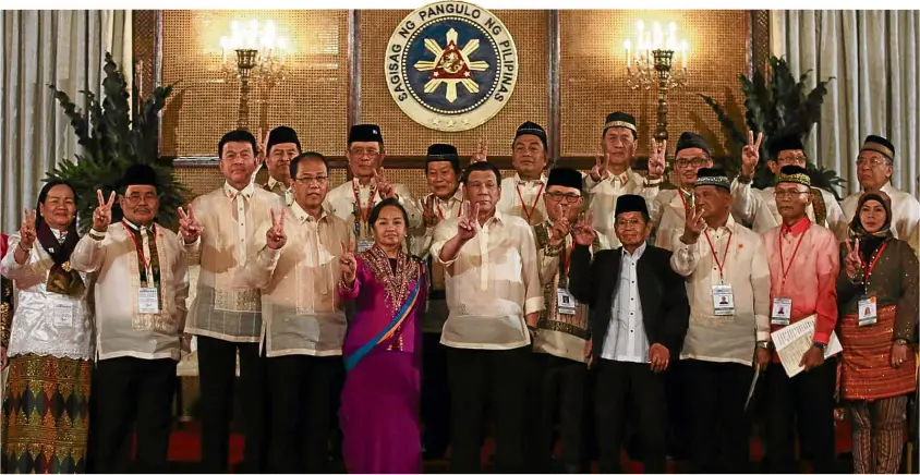  ?? —LYN RILLON ?? AMORO REGION IS BORN President Duterte, Speaker Gloria Macapagal-Arroyo and Chief Peace Adviser Carlito Galvez Jr. join Bangsamoro Transition Authority (BTA) Chief Minister Murad Ebrahim (seventh from left, front row), MILF vice chair Ghadzali Jaafar (eighth from left), MILF chief peace negotiator Mohagher Iqbal (second from left) and some of the members of the BTA interim parliament in Friday’s oathtaking and confirmati­on of the Bangsamoro Organic Law plebiscite results at Malacañang.