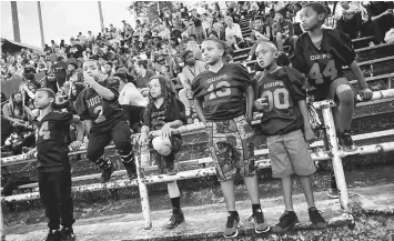  ??  ?? Aliquippa, Pennsylvan­ia, football fans sit in the rusting bleachers of Carl A. Aschman Stadium during a home-coming game. “The Pit” was built in 1937 and is sacred ground to fans who come to watch their beloved school’s football team.