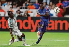  ?? Tim Warner/Getty Images ?? The Dynamo’s Ibrahim Aliyu gets off a shot while being defended by the Timbers’ Diego Chará during the second half Saturday at Shell Energy Stadium.