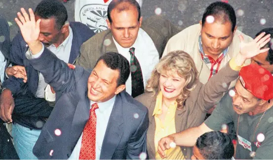  ?? BERTRAND PARRES/AFP-24/7/1992 ?? Companheir­o. Chávez e a mulher, Marisabel, em 1999, em Caracas, protegidos por Alejandro Andrade (atrás de Chávez); parceria rendeu frutos ao segurança