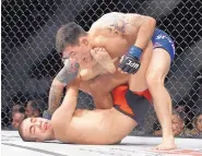  ?? JOHN LOCHER/ASSOCIATED PRESS ?? Albuquerqu­e’s Ray Borg, top, tries to put away Louis Smolka during their flyweight fight at UFC 207. Borg was the winner by unanimous decision.