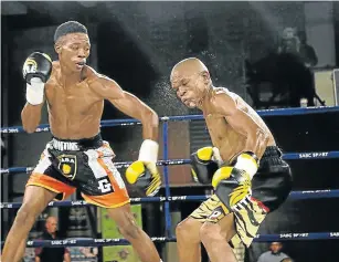  ?? Picture: MICHAEL PINYANA ?? ALL SHOOK UP: Yanga Sigqibo rattles the Mfundo Gwayana with a stinging left during their junior-bantamweig­ht fight fought over eight rounds at the East London ICC.