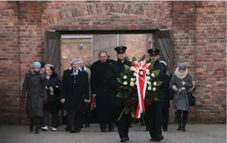  ?? CZAREK SOKOLOWSKI/THE ASSOCIATED PRESS ?? Soldiers hold a wreath at the former Auschwitz Nazi death camp in Poland on Internatio­nal Remembranc­e Day, which marks liberation of the camp.