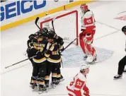  ?? ?? Boston Bruins players congratula­te Patrice Bergeron (37) after he scored a goal past Detroit Red Wings goaltender Magnus Hellberg (45) during the second period on Saturday in Boston.