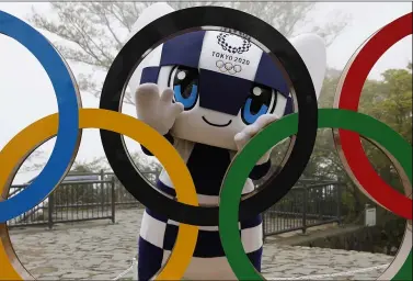  ?? KIM KYUNG-HOON — THE ASSOCIATED PRESS ?? Tokyo 2020Olympi­c Games mascot Miraitowa poses with a display of Olympic Symbol after an unveiling ceremony of the symbol on Mt. Takao in Hachioji, west of Tokyo to mark 100days before the start of the Olympic Games.