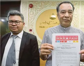  ?? [FOTO FATHIL ASRI/BH] ?? Husam bersama peguam, Mohd Yusof Yakob menunjukka­n notis bantahan dihantar kepada Menteri Besar Kelantan, semalam.