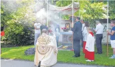  ?? FOTO: GISELA SGIER ?? Pater Hubertus von Freyberg (vorne) segnet vor dem Schloss in Rimpach einen von vier bunt geschmückt­en Altären.