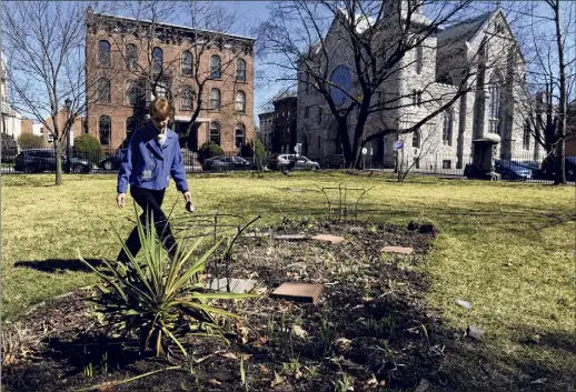  ?? Will Waldron / Times Union ?? Lynn Kopka, longtime president of the Washington Park neighborho­od group, examines one of the flowerbeds in the privately owned ornamental park on March 30 in Troy. Kopka recently stepped down from the position she held for 20 years.