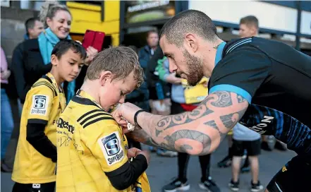 ?? GETTY IMAGES ?? Halfback TJ Perenara autographs a jumper, during the open training the Hurricanes held for members on Wednesday.