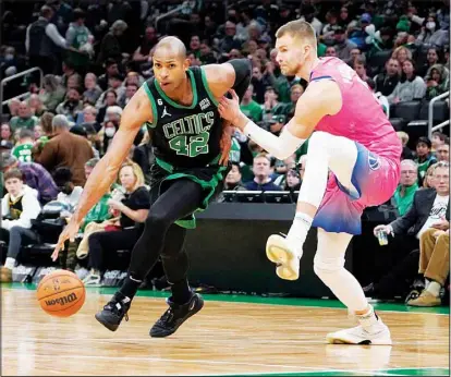  ?? ?? Boston Celtics center Al Horford (42) drives past Washington Wizards center Kristaps Porzingis during the second half of an NBA basketball game in Boston. (AP)