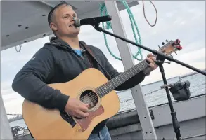  ??  ?? Simon LeBlanc sings some songs on the way back to the wharf during the Yarmouth harbour tour.