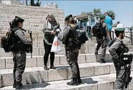  ?? ABIR SULTAN/EPA ?? Israeli border police question a Palestinia­n woman Sunday in the Old City of Jerusalem.