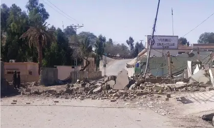  ?? Photograph: AFP/Getty Images ?? Security personnel stand beside a destroyed security post after attacks by militants in the Naushki district of Balochista­n province.