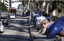  ?? AP PHOTO/RICHARD VOGEL ?? This Jan. 26 file photo shows tents from a homeless encampment line a street in downtown Los Angeles.