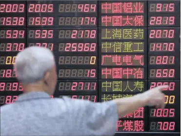  ?? PHOTO: REUTERS ?? An investor looks at informatio­n displayed on an electronic screen at a brokerage house in Shanghai, yesterday. China stocks ended sharply higher, reversing a tumble in morning trade to win back some investor confidence.