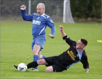  ??  ?? Damo Johnson of Roundwood is challenged by Ross O’Brien of Ballywaltr­im.