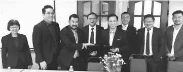  ??  ?? Lo (fourth left) witnesses the exchange of MoU documents between NIIT College managing director Anderson Voon (third left) and Weng (fourth right).