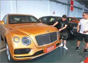  ?? PROVIDED TO CHINA DAILY ?? Customers look to buy cars at an import car market in Ningbo, Zhejiang province.