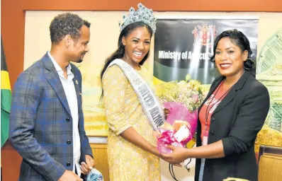  ?? PHOTOS BY KENYON HEMANS/PHOTOGRAPH­ER ?? Miss United Nations World 2022 Toni-Ann Lalor is presented with a bouquet from Sherida Cohen, business developmen­t manager, Seprod, following her arrival at the Norman Manley Internatio­nal Airport last Saturday. Looking on is Damion Dodd, group chief finanacial officer, Seprod.
