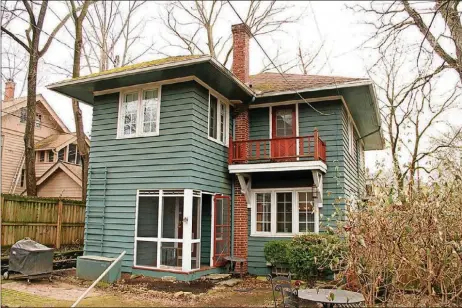  ??  ?? A screen-enclosed porch is off the updated kitchen. The porch opens out to a courtyard backyard with a brick patio and tiered gardens and surrounded by a wooden fence.