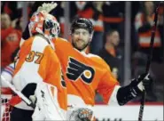  ?? TOM MIHALEK — THE ASSOCIATED PRESS ?? Philadelph­ia Flyers’ Andrew MacDonald, right, congratula­tes goalie Brian Elliott after Saturday’s win over the New York Rangers.