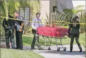  ?? Irfan Khan Los Angeles Times ?? THE BODY of one victim is taken out of the Casa De Portola apartments in Garden Grove on Wednesday.