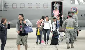  ?? COLPRENSA ?? Momentos en que el grupo de los 25 colombiano­s rescatados en San Martín bajan del avión de la Fuerza Aérea Colombiana, ayer en Bogotá.