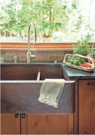  ?? HOUZZ PHOTO ?? This leathered look apron sink is a refreshing change from stainless or white and makes an unusual focal point for a kitchen.