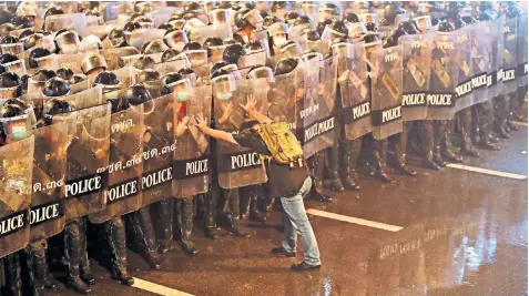  ??  ?? Pro-democracy protesters face riot police, armed with water cannons, riot shields and batons, sent in to quell demonstrat­ions being held in defiance of a ban on such gatherings